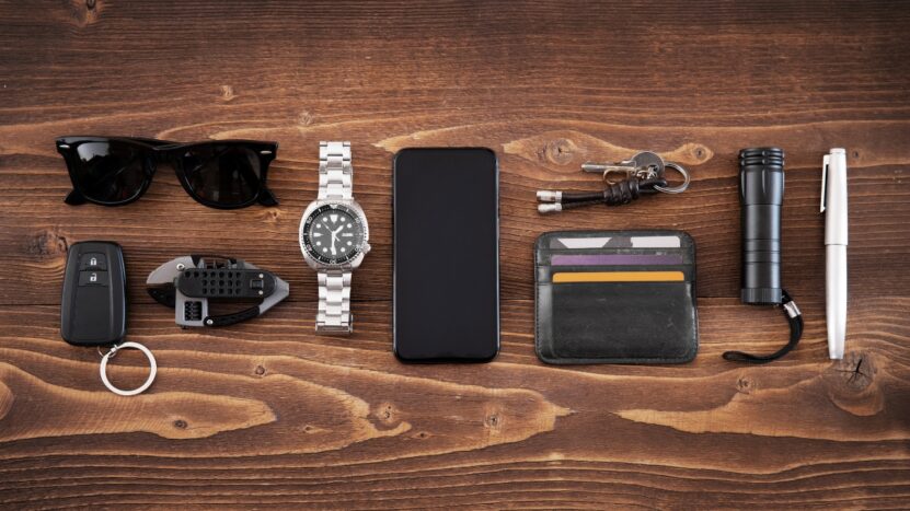 Everyday carry items are laid out neatly on a wooden table