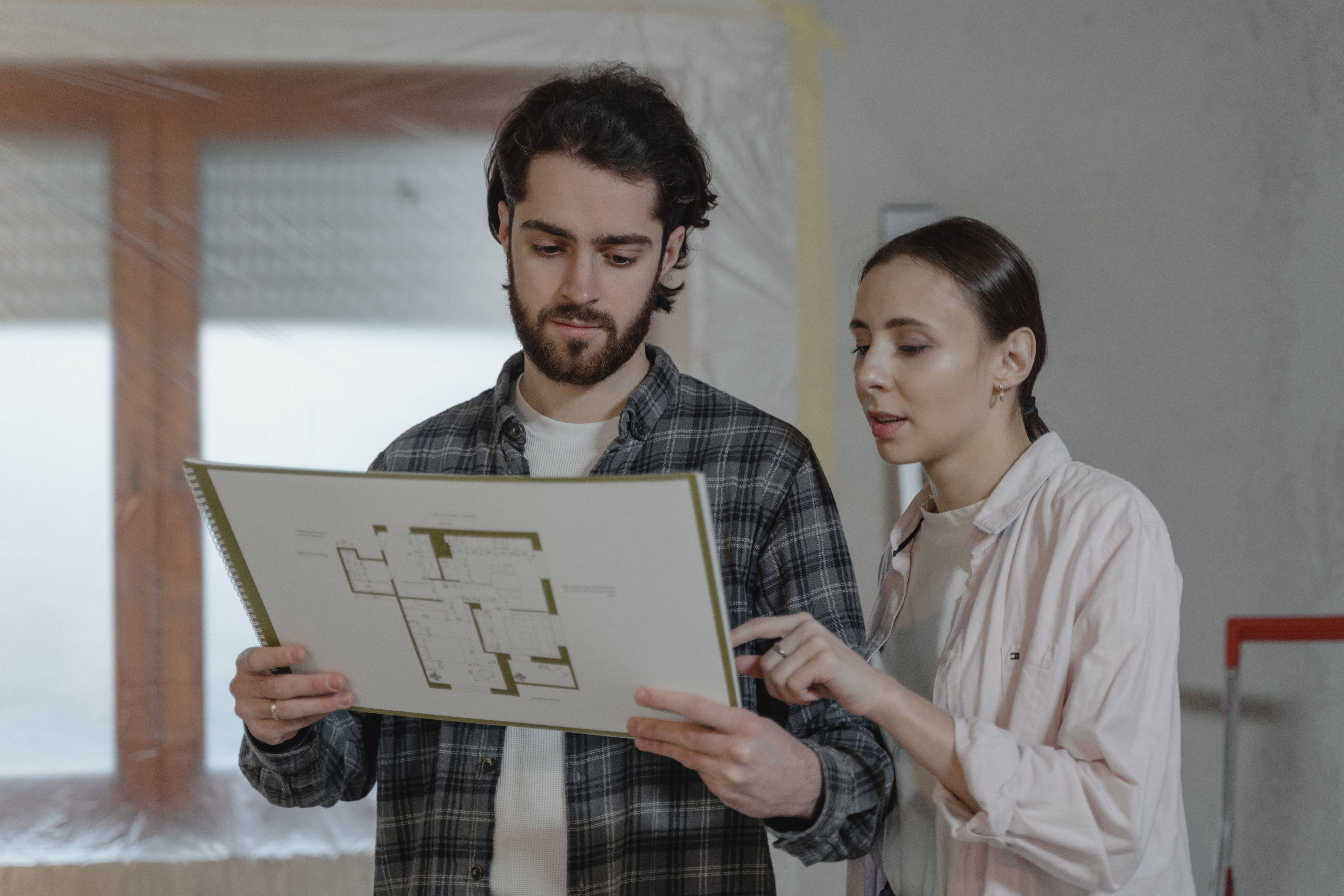 Man and woman examining a floor plan for a home improvement project.