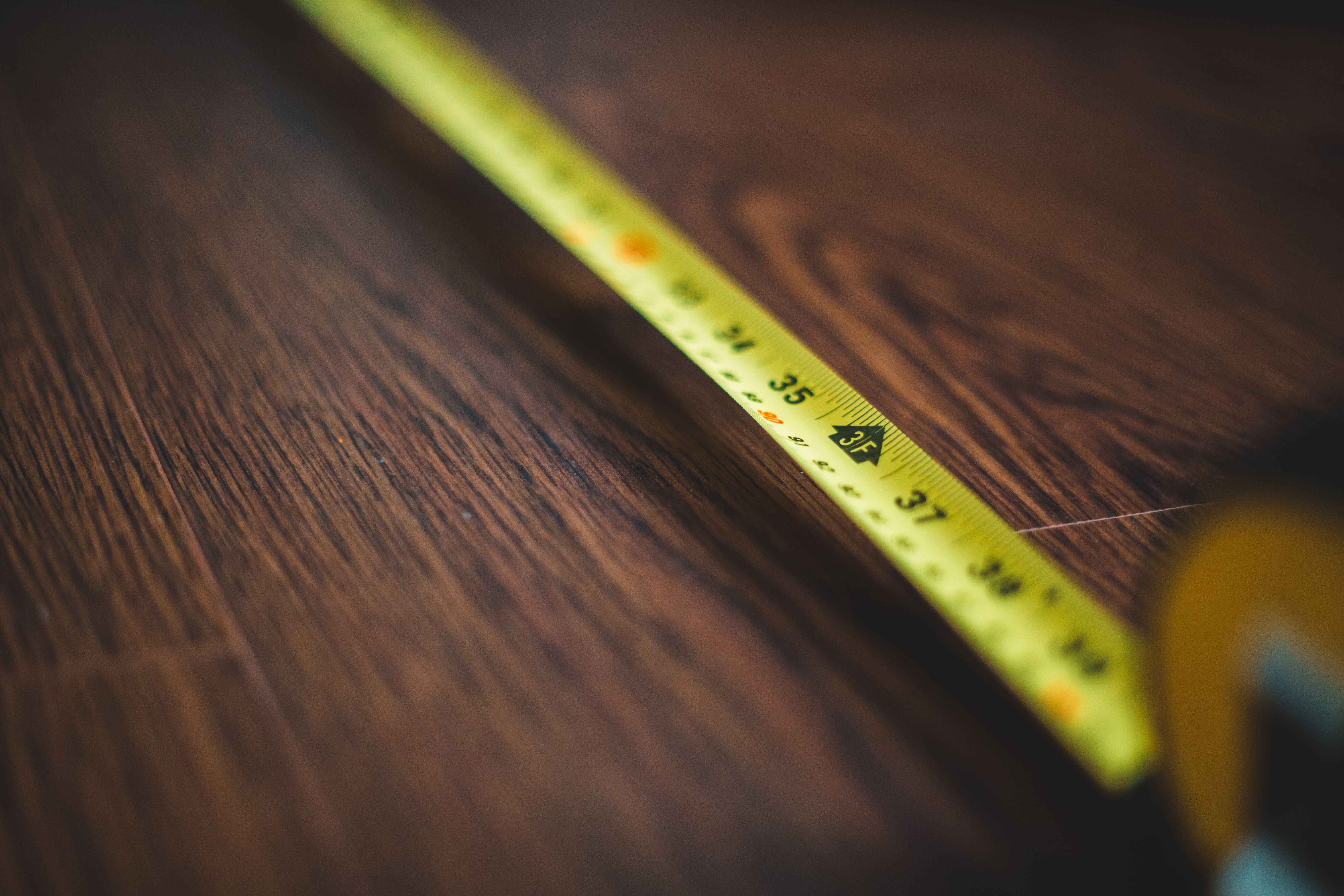 Tape measure on a wooden floor representing accurate room measurements for renovation planning.